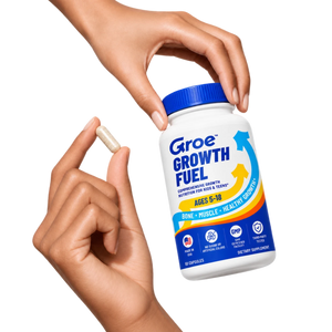 A hand holding the Groe Growth Fuel bottle