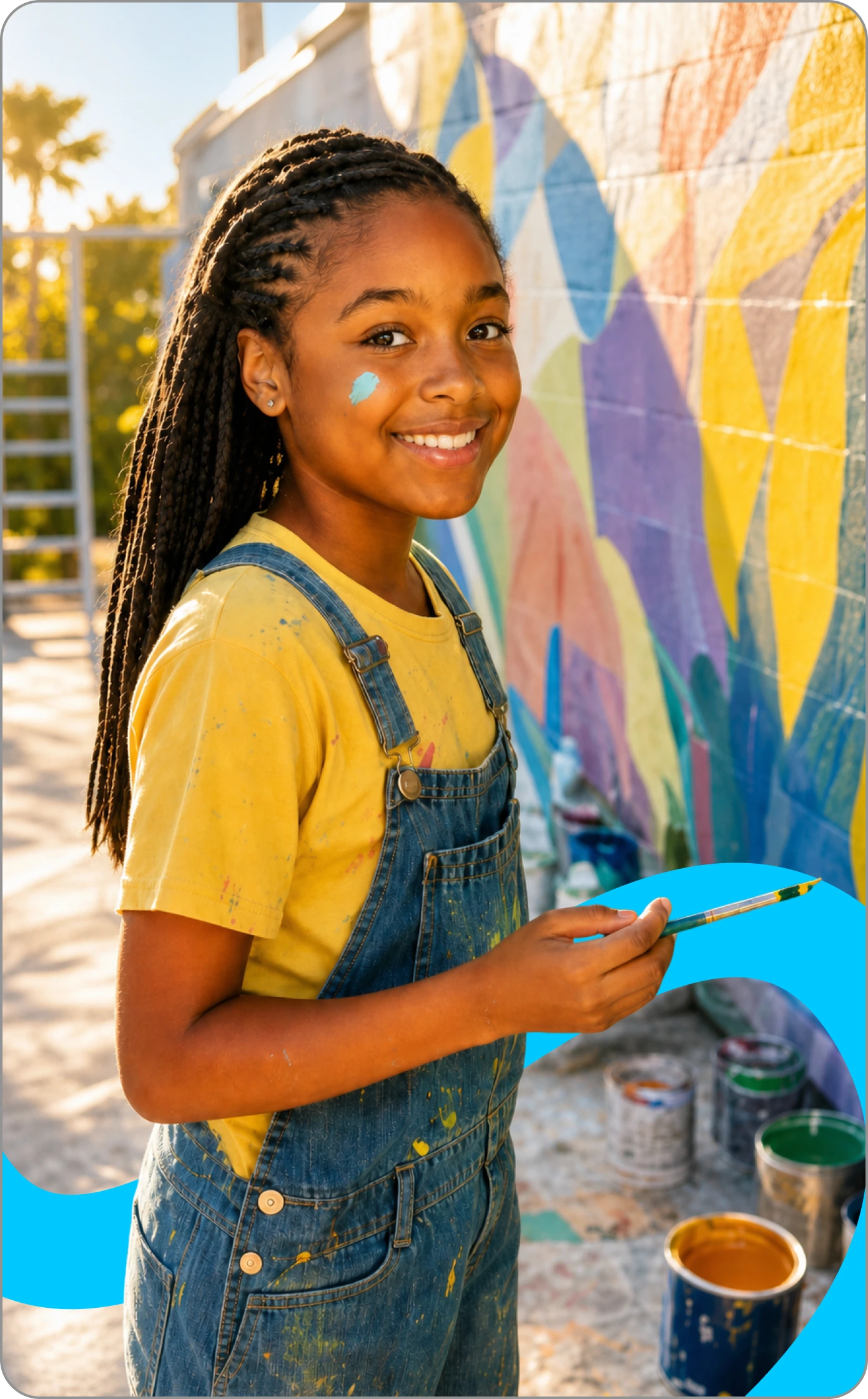 Girl painting a brightly coloured mural outdoors.